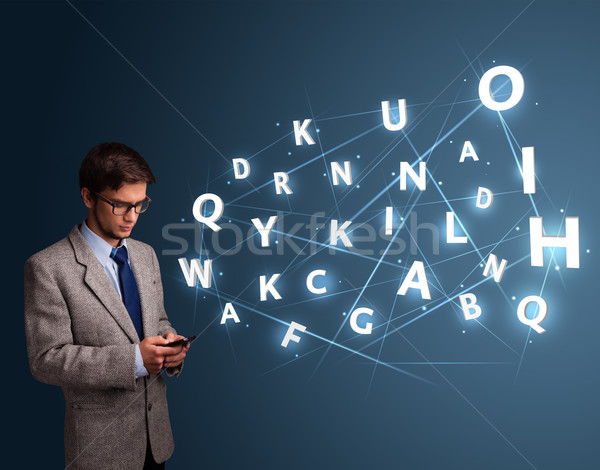 Handsome young man typing on smartphone with high tech 3d letters comming out Stock photo © ra2studio