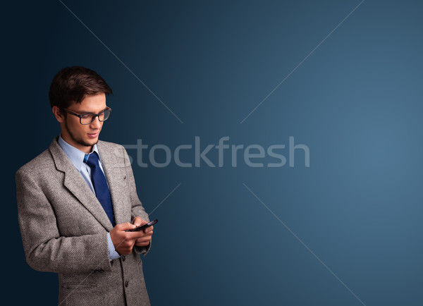 [[stock_photo]]: Jeune · homme · permanent · tapant · téléphone · espace · de · copie · élégant