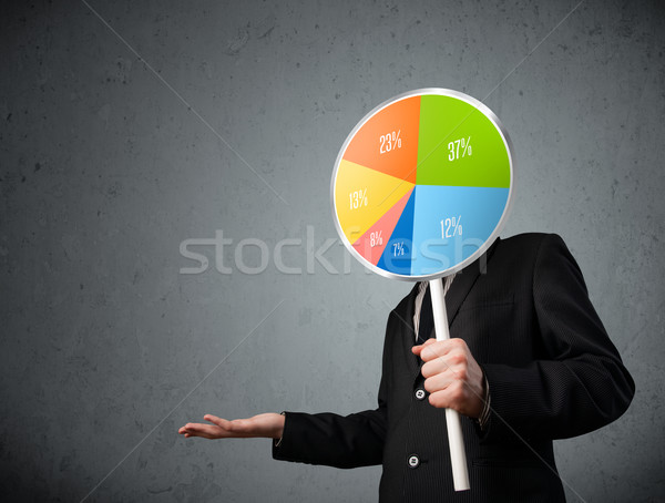 Businessman holding a pie chart Stock photo © ra2studio