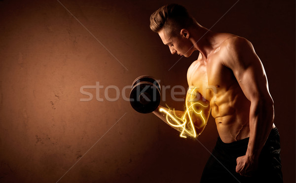 Muscular body builder lifting weight with energy lights on bicep Stock photo © ra2studio