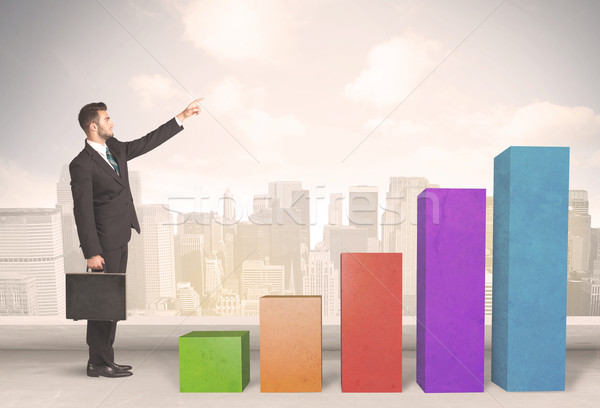 Stock photo: Business person climbing up on colourful chart pillars concept