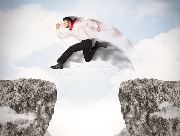 Grappig zakenman springen rotsen kloof business Stockfoto © ra2studio
