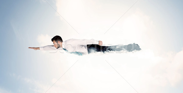 Business man flying like a superhero in clouds on the sky Stock photo © ra2studio