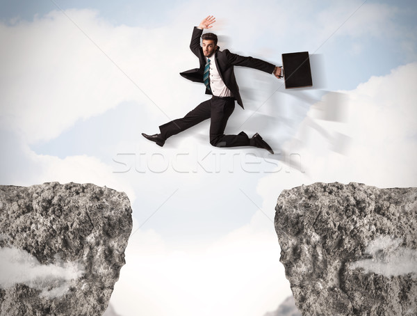 Amuzant om de afaceri jumping roci decalaj afaceri Imagine de stoc © ra2studio