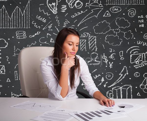 Businesswoman sitting at desk with business scheme and icons Stock photo © ra2studio