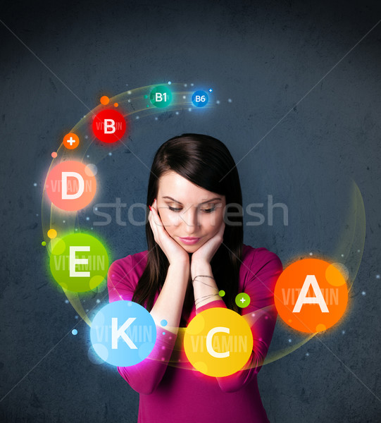 Young woman thinking with vitamins circulation around her head Stock photo © ra2studio
