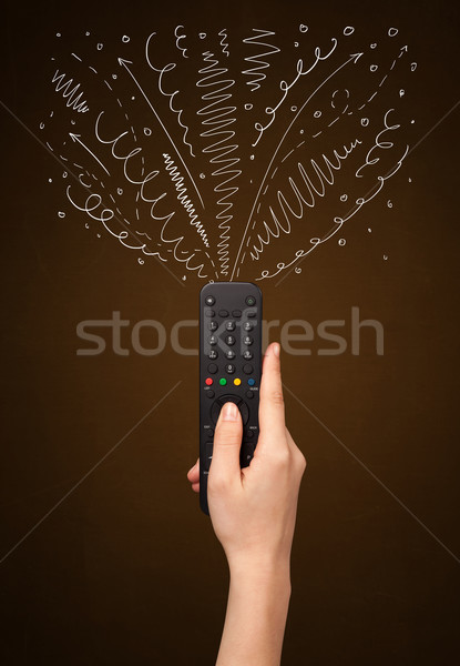 Hand with remote control and curly lines Stock photo © ra2studio