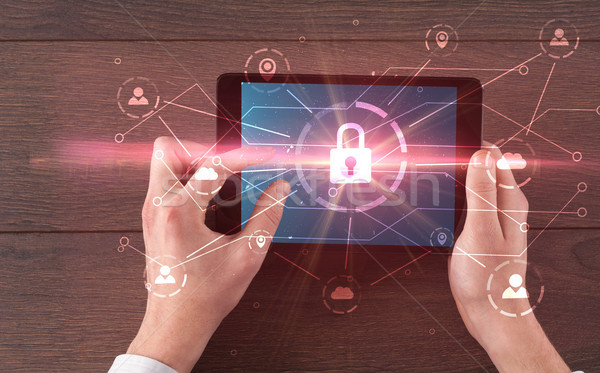 Stock photo: Hand using tablet with network security and online storage syste