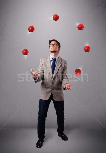 young man standing and juggling with red balls Stock photo © ra2studio