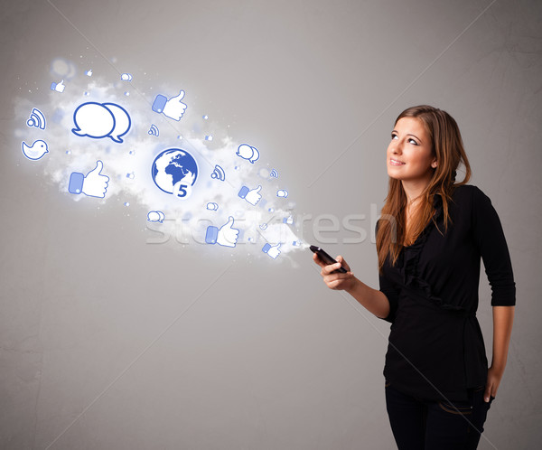 Stock photo: Pretty young girl holding a phone with social media icons