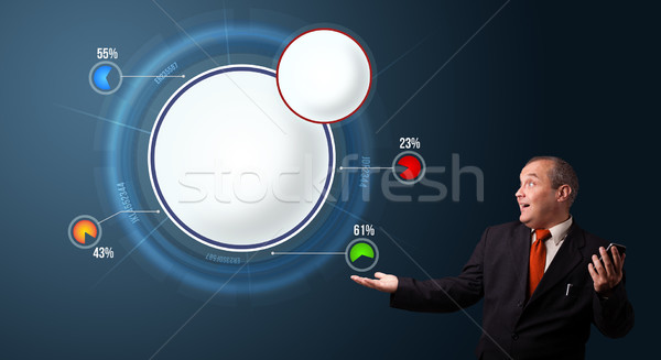 crazy businessman in suit holding a phone and presenting abstract modern pie chart Stock photo © ra2studio