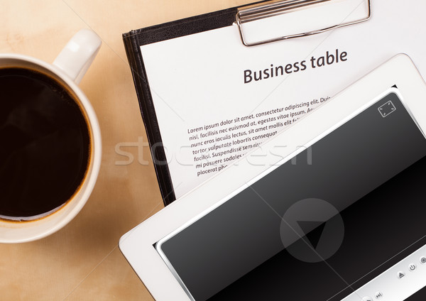 Workplace with tablet pc showing media player and a cup of coffee on a wooden work table closeup Stock photo © ra2studio