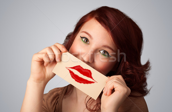 Happy pretty woman holding card with kiss lipstick mark Stock photo © ra2studio