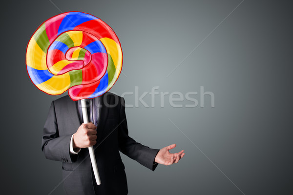 Businessman holding a lollipop Stock photo © ra2studio
