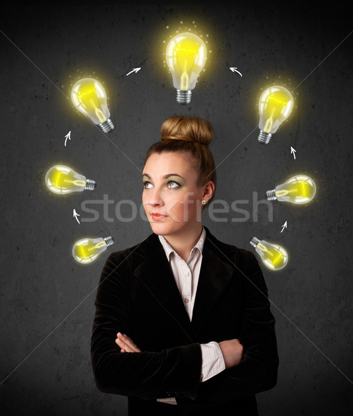 Young woman thinking with lightbulb circulation around her head Stock photo © ra2studio