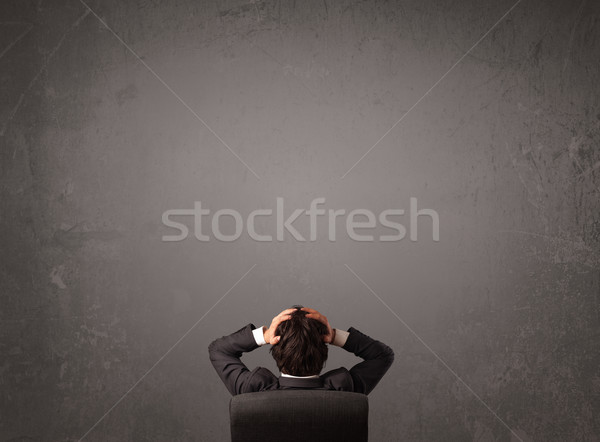 Businessman sitting in front of a wall with copy space Stock photo © ra2studio