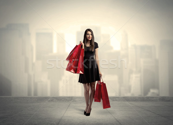 Elegant city girl with red shopping bags Stock photo © ra2studio