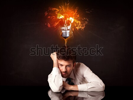 Businessman sitting under a blowing idea bulb Stock photo © ra2studio