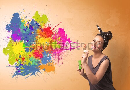 Stock photo: Cute girl blowing colorful splash graffiti 