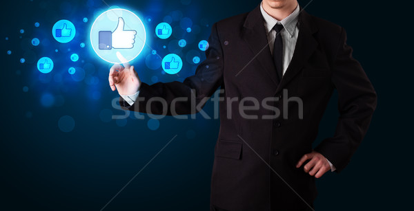 Handsome person pressing thumbs up button on modern social netwo Stock photo © ra2studio