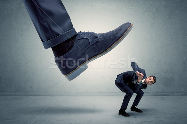 Employee getting trampled by big shoe Stock photo © ra2studio