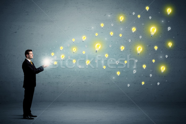 Businessman holding lightbulbs Stock photo © ra2studio