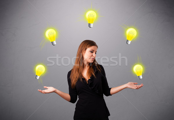 young lady standing and juggling with light bulbs Stock photo © ra2studio