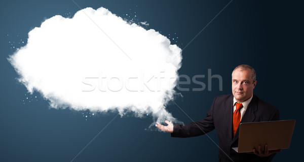 Businessman in suit holding a laptop and presenting abstract cloud copy space Stock photo © ra2studio
