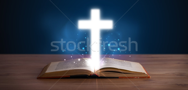 Open holy bible with glowing cross in the middle Stock photo © ra2studio