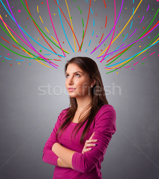 Young girl thinking with colorful abstract lines overhead Stock photo © ra2studio