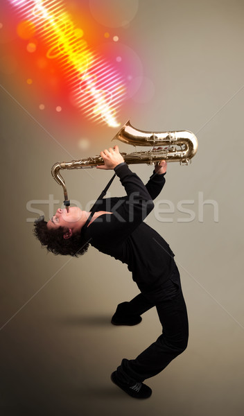 Joven jugando saxófono colorido sonido olas Foto stock © ra2studio