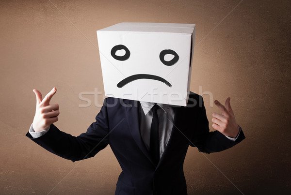 Stock photo: Businessman gesturing with cardboard box on his head with sad fa