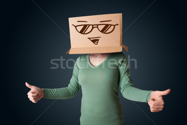 Stock photo: Young lady gesturing with a cardboard box on her head with smile