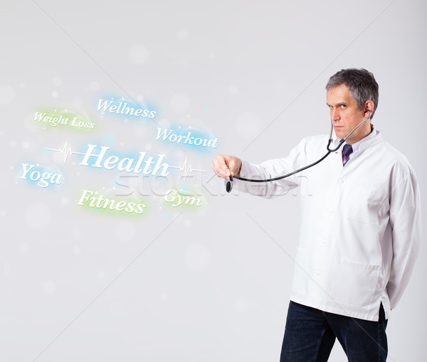 Clinical doctor pointing to health and fitness collection of wor Stock photo © ra2studio