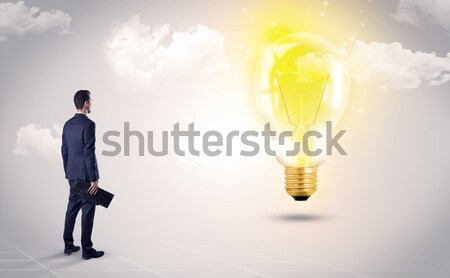 Businessman on rock mountain with idea bulb Stock photo © ra2studio