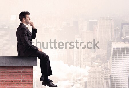 Office worker sitting on rooftop in city Stock photo © ra2studio