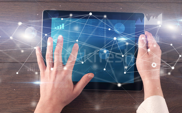 Hand holding tablet with linked graphs and charts concept Stock photo © ra2studio