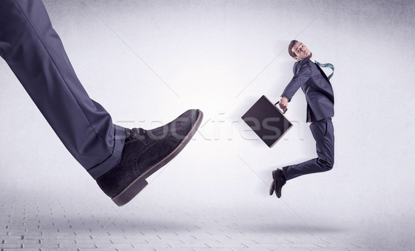 Young worker kicked out by big foot Stock photo © ra2studio