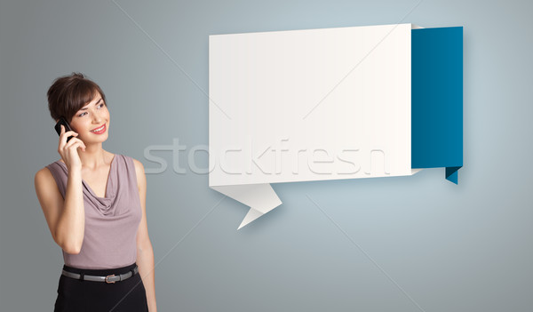 pretty young woman standing next to modern origami copy space and making phone call Stock photo © ra2studio