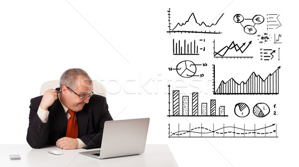 Businessman sitting at desk with diagrams and laptop Stock photo © ra2studio
