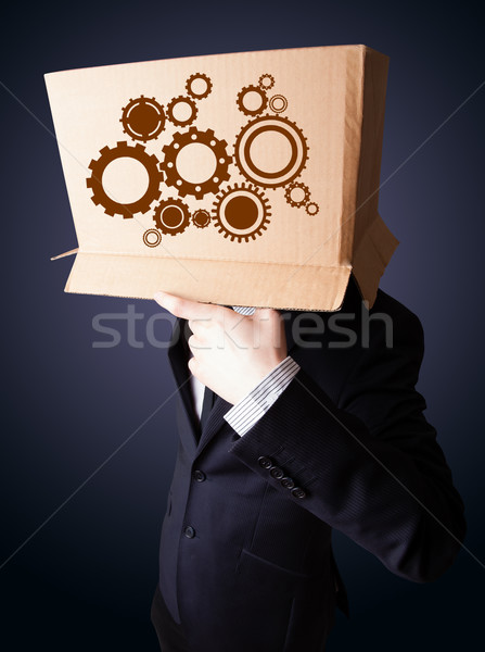 Businessman gesturing with a cardboard box on his head with spur Stock photo © ra2studio