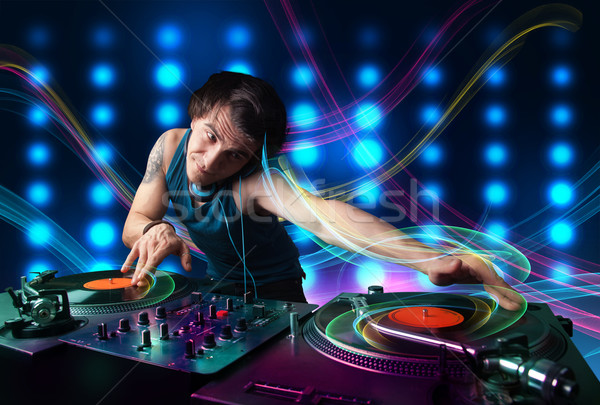 Young Dj mixing records with colorful lights Stock photo © ra2studio