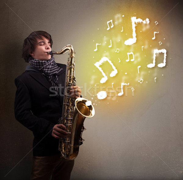Handsome musician playing on saxophone with musical notes Stock photo © ra2studio