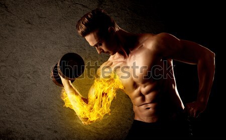 Bodybuilder athlete lifting weight with fire explode arm concept Stock photo © ra2studio