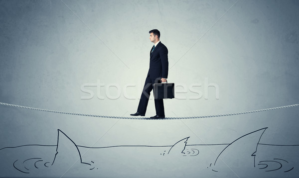 Businessman walking on rope above sharks Stock photo © ra2studio