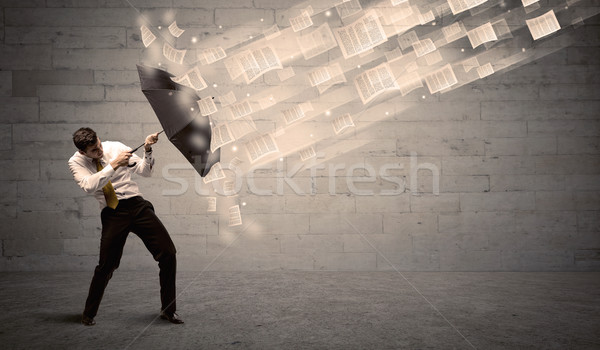 Business man protecting with umbrella against wind of papers Stock photo © ra2studio