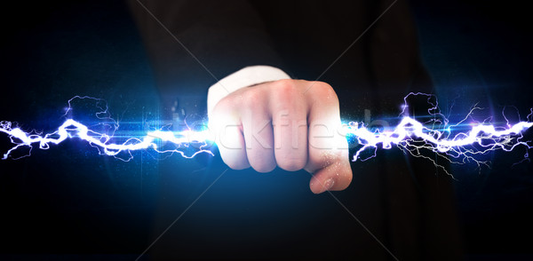 Business man holding electricity light bolt in his hands Stock photo © ra2studio