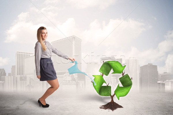 Business woman watering green recycle sign tree on city backgrou Stock photo © ra2studio