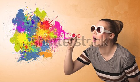 Stock photo: Cute girl blowing colorful splash graffiti 