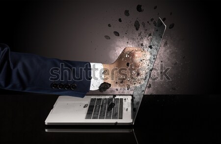 Hand with hammer coming out of a laptop Stock photo © ra2studio